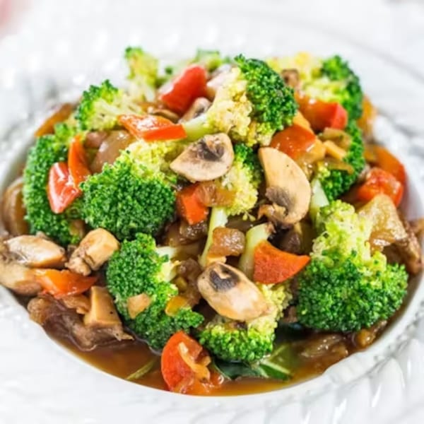 A Thai dish with broccoli, mushrooms, and red bell peppers in a savory sauce.